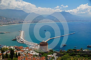 View on a Mediterranean sea coastline in Turkish city of Alanya with foggy mountains under cumulus clouds on the horizon