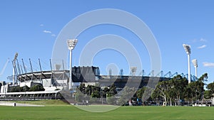 View of the Melbourne Cricket Ground with green grass and blue sky background on a sunny day