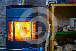 View of a metal furnace with tempered refractory glass, in which a bright flame of fire burns
