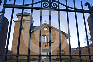 A view through a metal gate of Old Truchas Mission of the Holy Rosary. photo