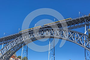 View of the metallic bridge of D. Maria Pia, built by Gustave Eiffel, with yellow subway wagon, in Porto