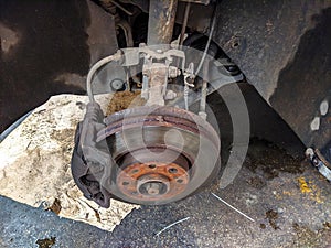 View of metallic car disk where tire stands and other car mechanical machinery in a car mechanics and repair store, waiting for