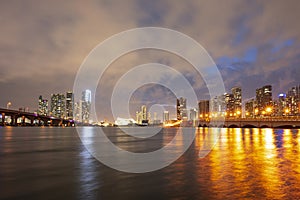 View of Miami at sunset, USA. Miami city skyline panorama at dusk with urban skyscrapers and bridge over sea with