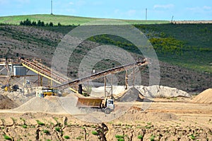 View on the mining quarry for the production of crushed stone, sand and gravel. Crusher plant with belt conveyor, crushing process