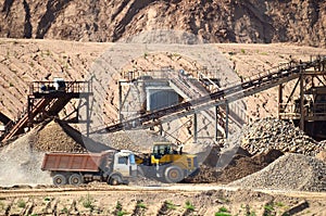 View on the mining quarry for the production of crushed stone, sand and gravel. Crusher plant with belt conveyor, crushing process