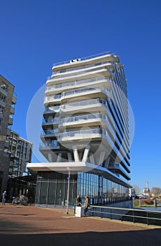 View on modern architcture dpg media building in dutch river harbor against blue sky