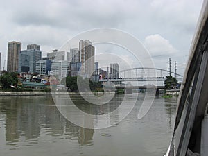 View of modern buildings and the Mandaluyong Boni and Guadalupe bridges along the Pasig river, Manila, Philippines photo