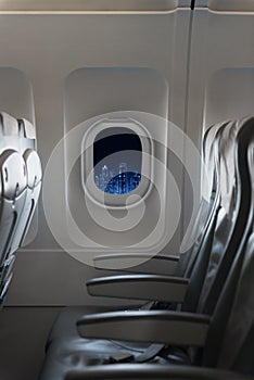 View of modern city skyline at night in an airplane window