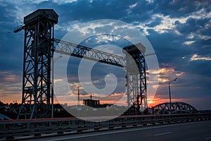 View of modern concrete bridge over river at sunset