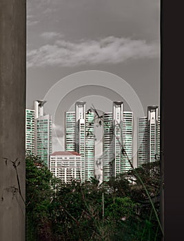 View of Modern high buildings among green trees space in nature against blue sky with clouds at afternoon