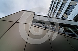 View through modern high rising skyscraper upwards to blue sky with white clouds - abstract architecture detail background