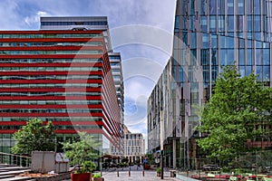 View of modern high skyscrapers for business and offices in Amsterdam, with streets, trees, flower boxes, restaurants and shopping