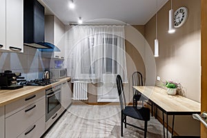 View of a modern kitchen with blue hood, kitchen appliances and dining table