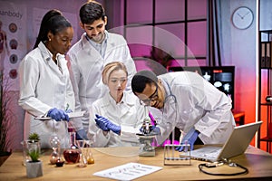 View of modern university research laboratory with multiracial team of young scientists