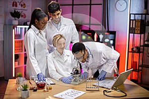 View of modern university research laboratory with multiracial team of young scientists