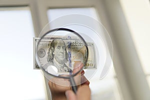 view money under a magnifying glass. Counterfeiter forges banknotes. Fake concept. Fake money American dollars photo