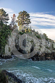 View into Monkey bay, rocky cove with trees with crystal clear blue water. New Zealand