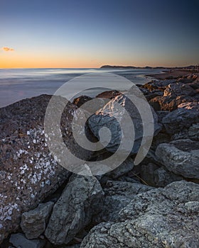 View of Monte San Bartolo and Gabicce from the beach of Riccione at sunrise, in Italy