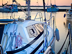 Moored sailing yacht hull and rigging on a pier, dawn waterscape view