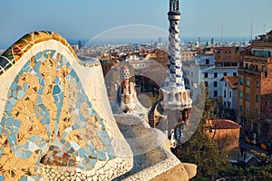 View from the mosaic Serpentine bench wall of the Park Guell to the pinnacle of administration office and panorama of