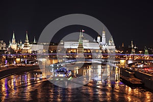 View of Moscow at night with a panorama of the Moscow Kremlin and a large stone bridge over the Moscow river. Moscow