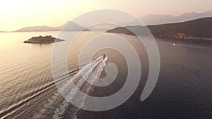 View of a motor boat sailing against the background of Mamula Island, mountains and picturesque slopes in the Bay of