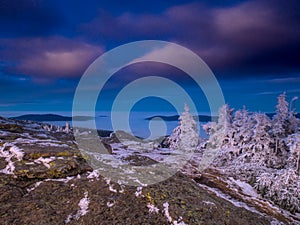 View from a mounatin range to the valey filled with low clouds and fog during temperature inversion