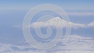 View of Mount Ararat from an airplane. Snow-capped mountain top. Biblical mount Ararat taken from the Airplane