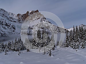 View of Mount Edith Cavell with Angel Glacier in late autumn with hiking path in snow-covered landscape and trees in Canada.