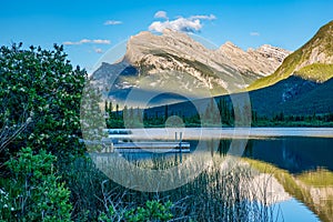 View of Mount Rundle reflected in the water of Vermillion Lakes in Banff