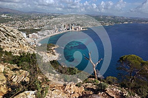 View from the mountain Ifach on a steep stony slope, the blue sea and coastal town of Kalp on the Mediterranean coast in Spain, th