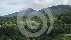 view Mountain peaks are covered tropical forest under clouds. Lake,mountain, clouds, blue sky, Bali, Indonesia. Mountain