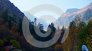 View of mountain valley covered with sunshine at background and with shadow at foreground. Warm autumn day in Dombai