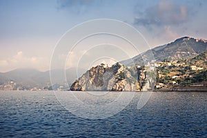View of the mountain village of Cornilla, Cinque Terra from the sea. View of Liguria, Italy, Europe. Seascape of Mediterian sea