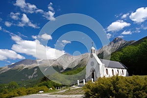 view of the mountains and chapel, with clear blue skies and white clouds