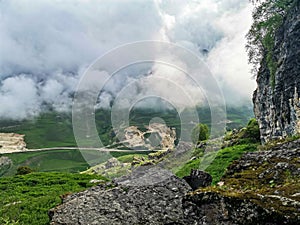 View of the mountains in the clouds and the entrance to the stone bowl. Dagestan. Russia