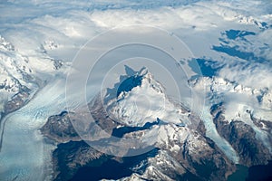View of Mountains, Low Clouds and Glaciers from the Plane Window