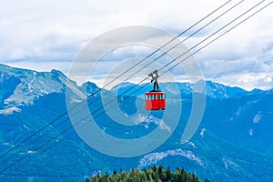 View of mountains and red Seilbahn cable car gondola from Zwolferhorn mountain