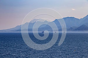 View of mountains and ships in a blue haze off the Mediterranean coast. Antalya, Turkey