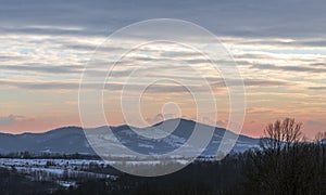 View of the mountains with spectacular clouds above them in the sunset