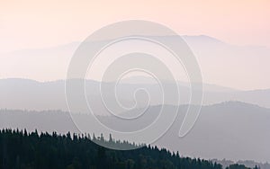 View of a mountains valley in a early morning with fog between hills. Mountains ranges layers.