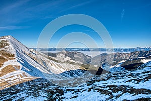 Pohľad na hory západných Tatier a dolinu s hmlou a modrou oblohou z hrebeňa v Nízkych Tatrách, Slovensko