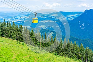 View of mountains and yellow Seilbahn cable car gondola from Zwolferhorn mountain