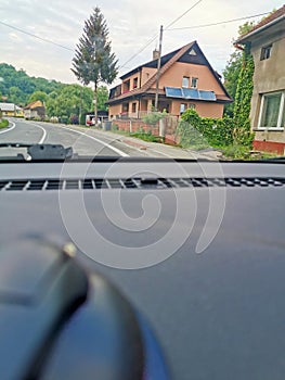 View from a moving car driving through a village street and passing houses