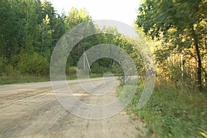 View from the moving car on the forest and countryside road at summer day.