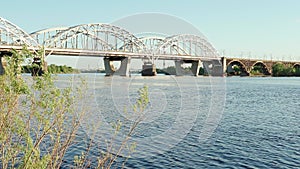 view moving fishing sailing motor boat on Dnipro river at sunrise sunset. landscape of industrial bridge over lake in