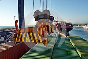 View on moving spreader of gantry crane observed from navigational bridge of container vessel.