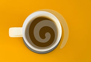 View of a mug of  blackcoffee isolted on yellow background