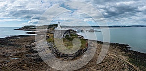 View of the Mumbles headland with the historic lighthouse and piers in Swansea Bay