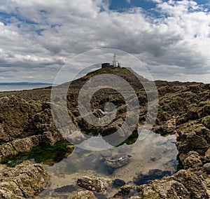 View of the Mumbles Lighthouse in Swansea Bay at low tide